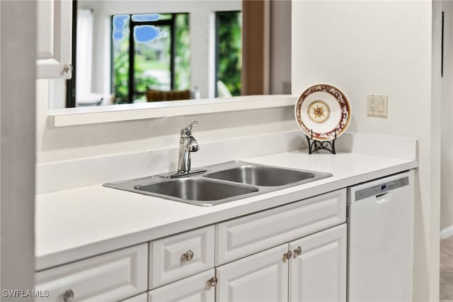 kitchen with dishwasher, sink, and white cabinets