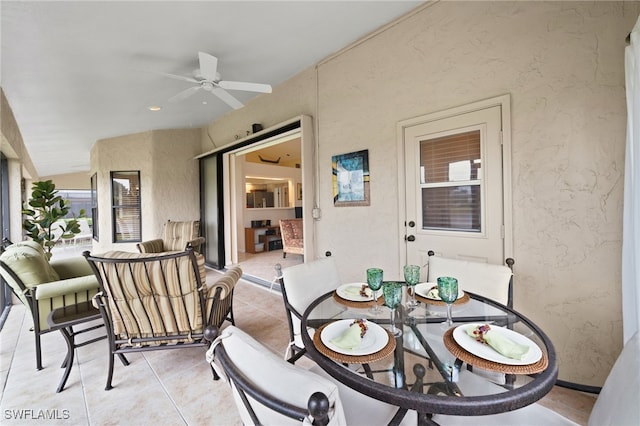 tiled dining space featuring ceiling fan and lofted ceiling