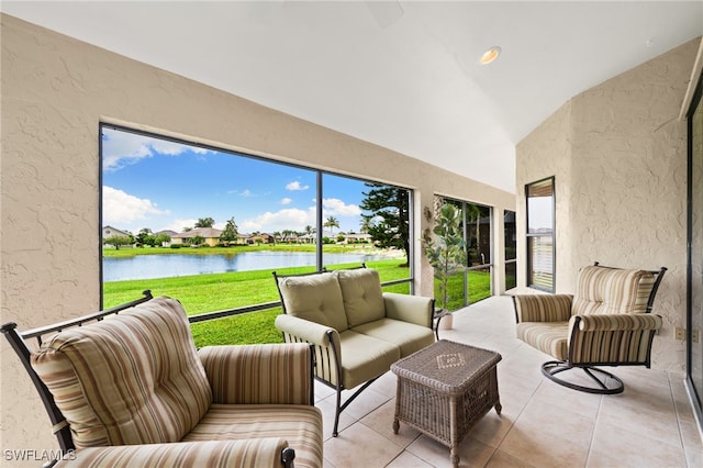 sunroom featuring vaulted ceiling and a water view