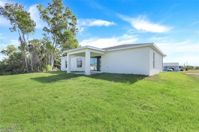 rear view of house featuring a yard