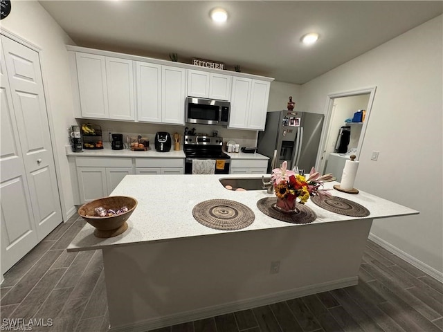 kitchen with a center island with sink, stainless steel appliances, and white cabinets