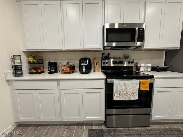 kitchen featuring white cabinetry, dark hardwood / wood-style flooring, and stainless steel appliances