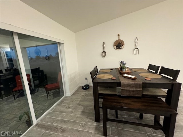 dining space with lofted ceiling and dark hardwood / wood-style floors