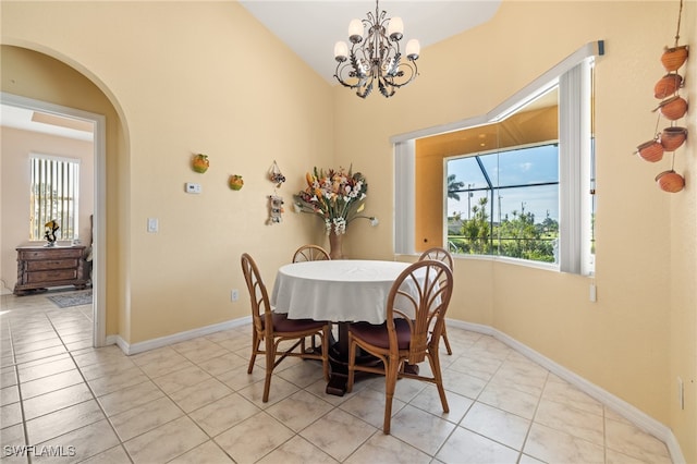 tiled dining area featuring vaulted ceiling and a chandelier