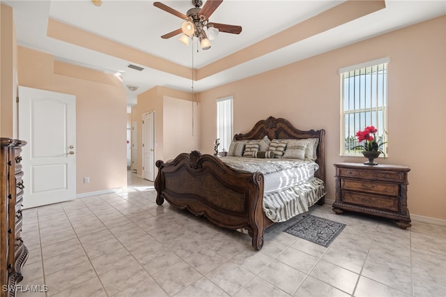 bedroom with ceiling fan and a tray ceiling