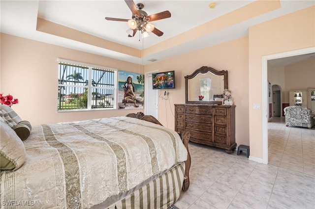 bedroom with a tray ceiling and ceiling fan