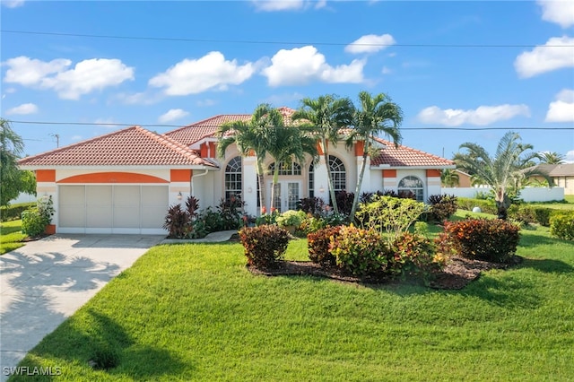 mediterranean / spanish house with a garage and a front lawn