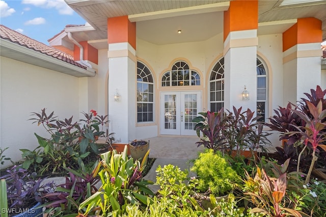 view of exterior entry with a patio and french doors