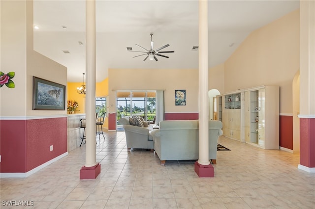 living room featuring ceiling fan with notable chandelier, light tile patterned flooring, and high vaulted ceiling