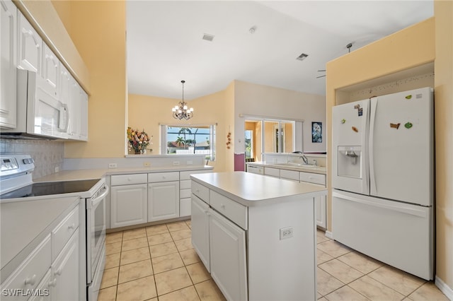 kitchen featuring tasteful backsplash, white cabinets, white appliances, a kitchen island, and a notable chandelier