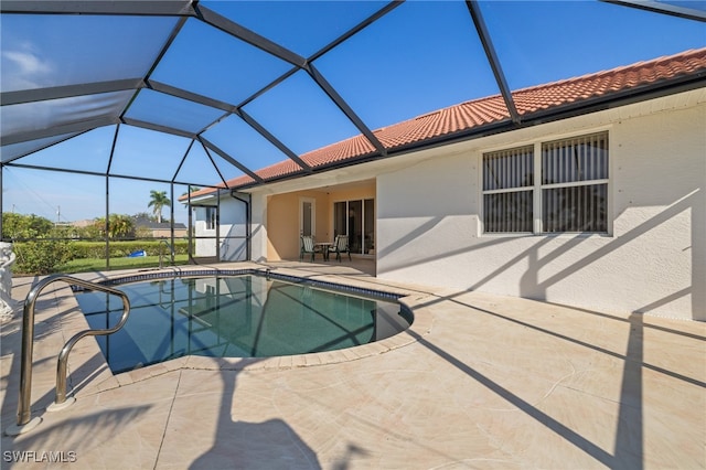 view of pool featuring glass enclosure and a patio