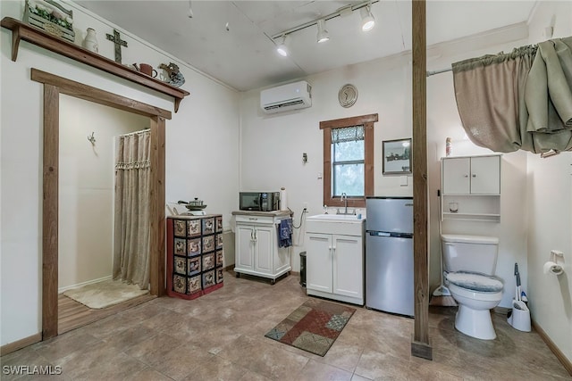 bathroom featuring rail lighting, a wall mounted air conditioner, vanity, and toilet