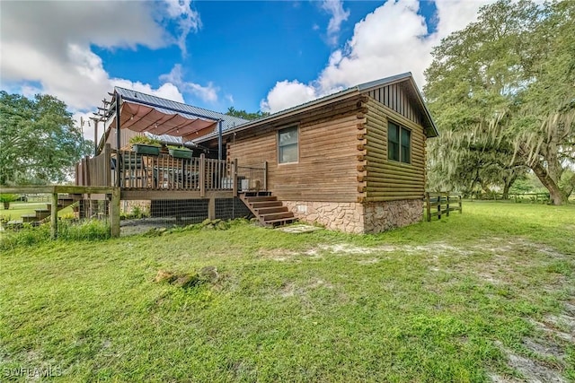 exterior space with a deck and a lawn