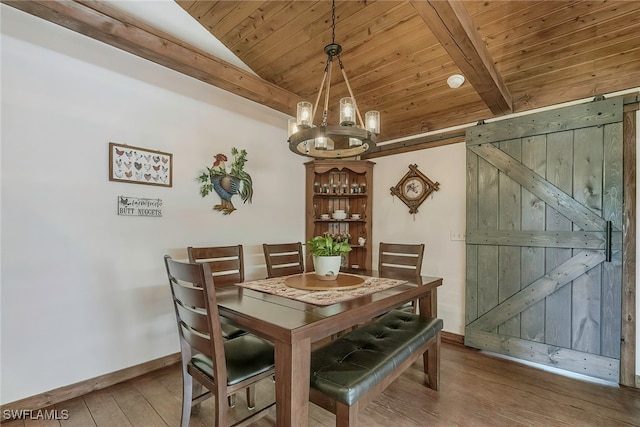 dining area with hardwood / wood-style flooring, vaulted ceiling with beams, a chandelier, wood ceiling, and a barn door