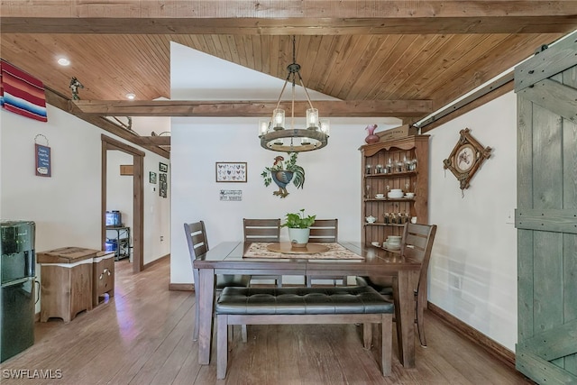 dining room featuring wood-type flooring, lofted ceiling with beams, wooden ceiling, an inviting chandelier, and a barn door