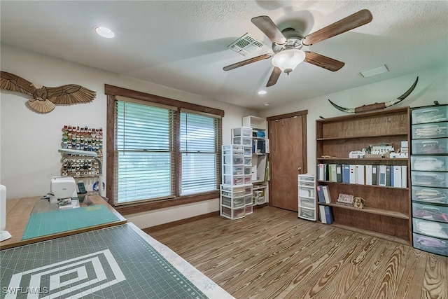 office space with light hardwood / wood-style flooring, ceiling fan, and a textured ceiling