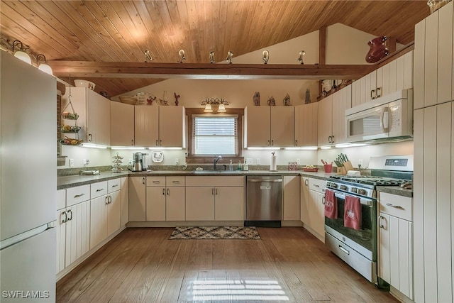 kitchen with appliances with stainless steel finishes, sink, vaulted ceiling, light wood-type flooring, and wood ceiling