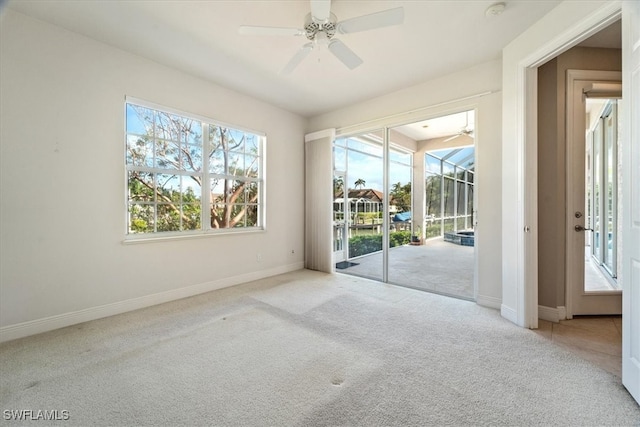 carpeted empty room featuring plenty of natural light and ceiling fan