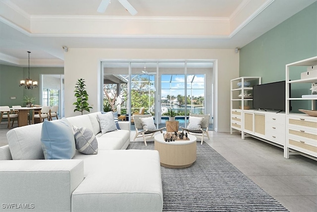 living room featuring ceiling fan with notable chandelier, a raised ceiling, a healthy amount of sunlight, and crown molding