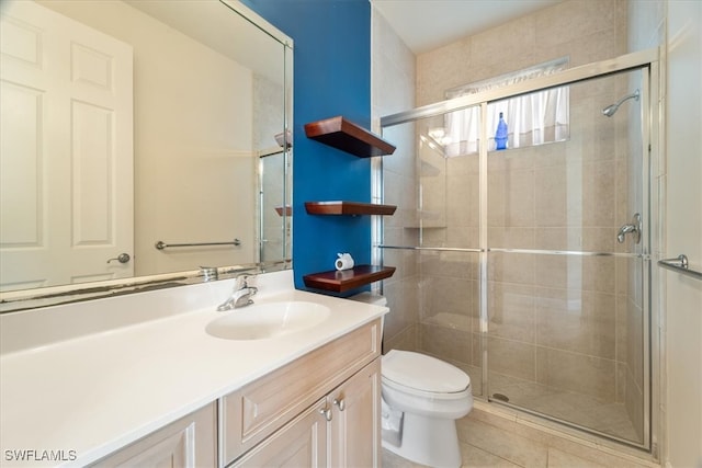 bathroom featuring toilet, vanity, tile patterned floors, and walk in shower