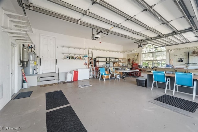 garage featuring a workshop area, a garage door opener, and water heater