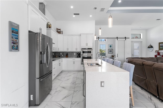 kitchen with a kitchen island with sink, stainless steel appliances, and a kitchen bar