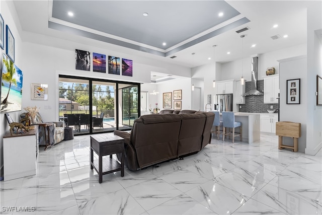 living room with a tray ceiling and a towering ceiling