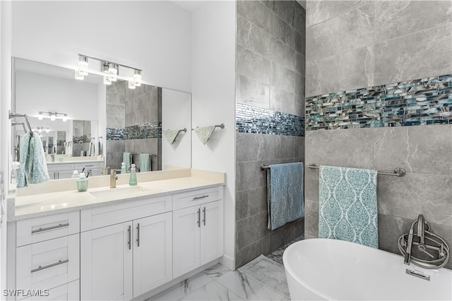 bathroom featuring a tub to relax in, vanity, and tile walls