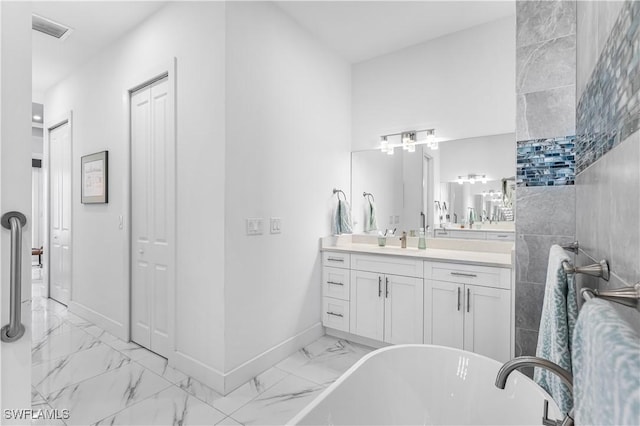 854 SW 15th Ave, Cape Coral, FL 33991 - full bathroom featuring visible vents, baseboards, a freestanding tub, marble finish floor, and vanity