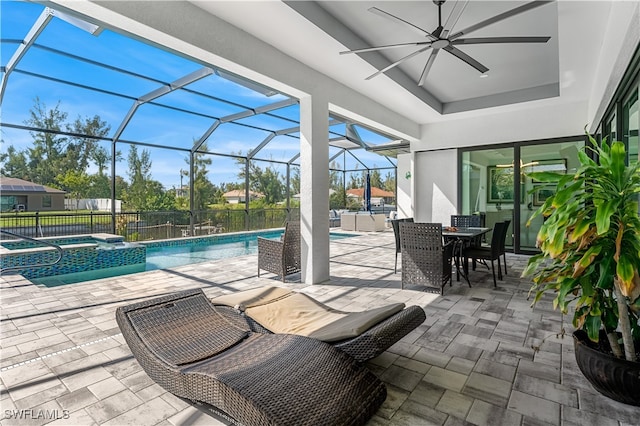 view of pool with an in ground hot tub, ceiling fan, a patio area, and a lanai