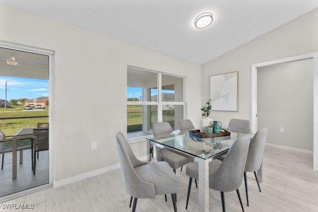 dining room with vaulted ceiling and light hardwood / wood-style floors