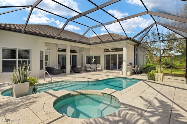 view of swimming pool with an in ground hot tub, ceiling fan, glass enclosure, and a patio area