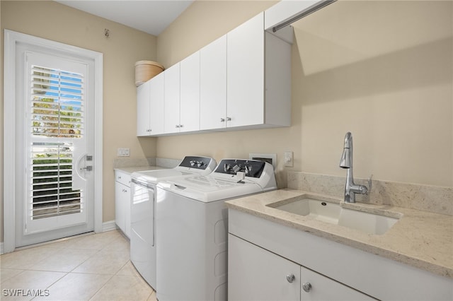 washroom featuring washer and dryer, cabinets, sink, and light tile patterned floors