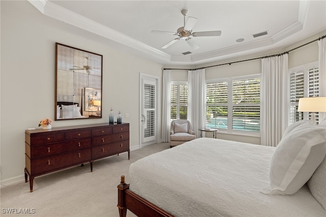 bedroom with ceiling fan, a raised ceiling, ornamental molding, and light colored carpet