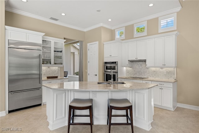 kitchen featuring a kitchen island with sink, white cabinets, stainless steel appliances, and plenty of natural light