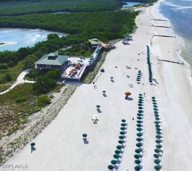 birds eye view of property featuring a water view and a beach view