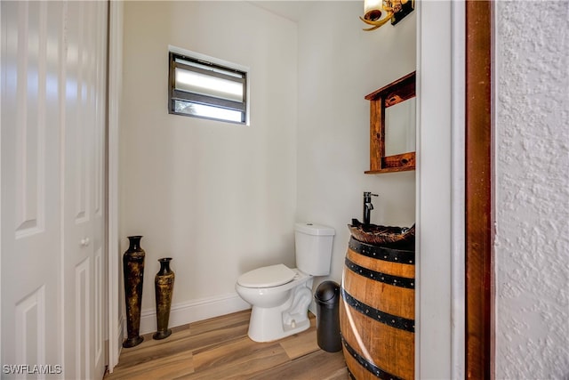 bathroom with wood-type flooring and toilet