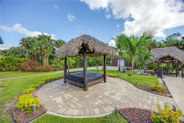 surrounding community with a gazebo, a storage unit, a patio area, and a lawn