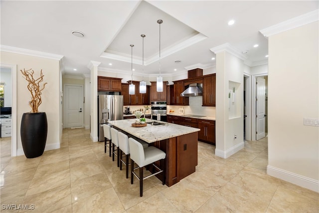 kitchen featuring stainless steel refrigerator with ice dispenser, crown molding, light stone counters, hanging light fixtures, and a kitchen island