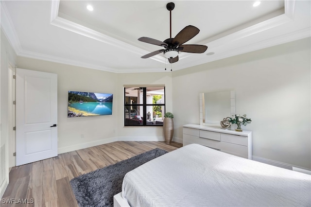 bedroom featuring crown molding, ceiling fan, a raised ceiling, and light hardwood / wood-style floors