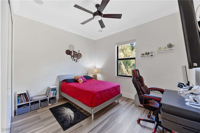 bedroom with light hardwood / wood-style flooring, ornamental molding, and ceiling fan