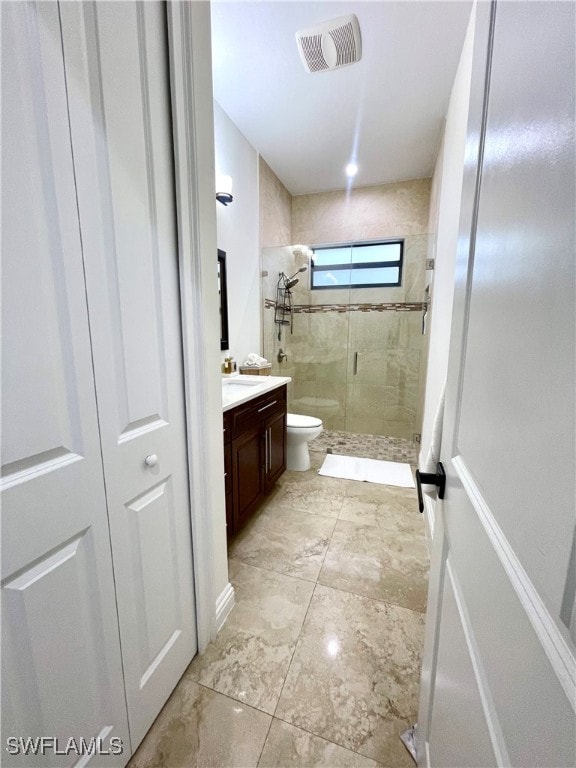 bathroom featuring vanity, an enclosed shower, and toilet