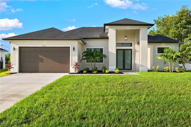 prairie-style home with a garage, a front yard, stucco siding, french doors, and driveway