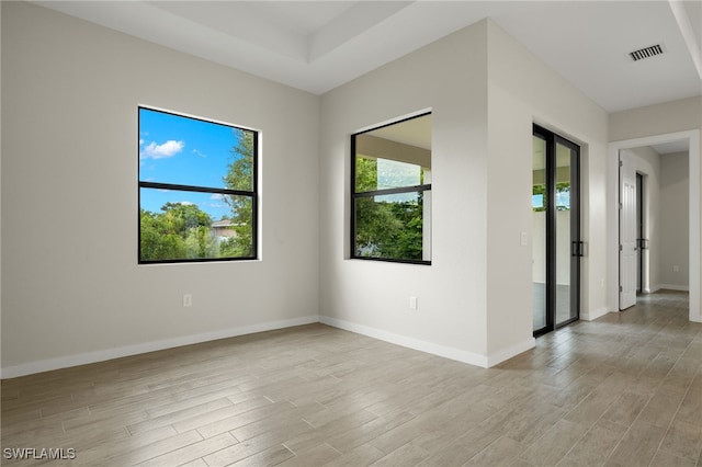 spare room with baseboards, visible vents, and light wood-style flooring