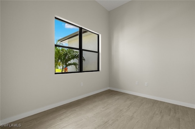 unfurnished room with baseboards and light wood-style flooring