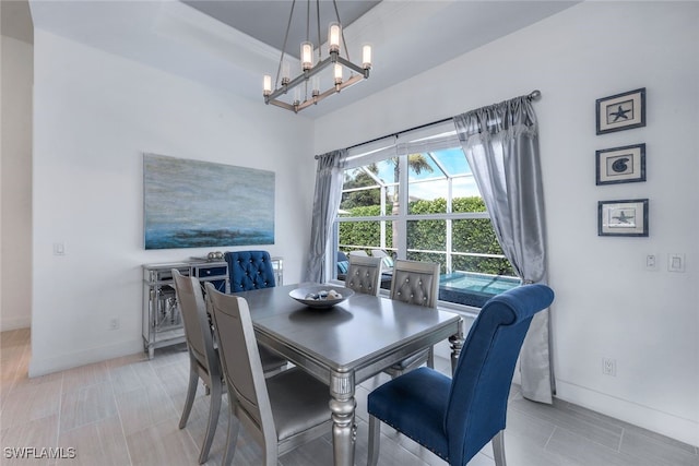 dining room with a chandelier and baseboards