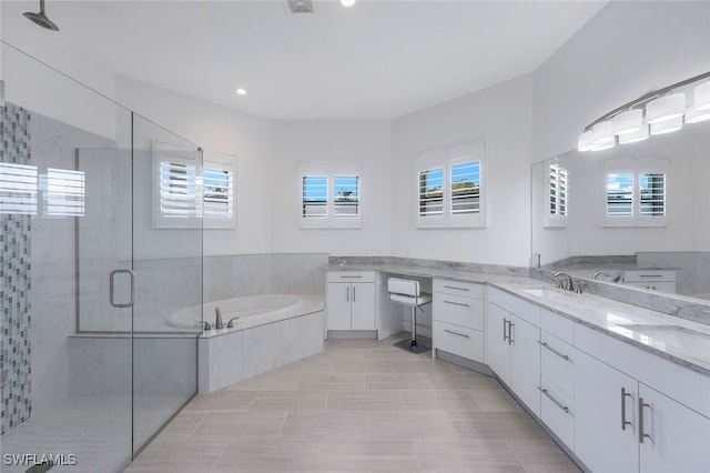 full bath with a stall shower, vanity, and a bath