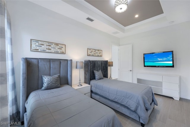 bedroom with a tray ceiling and recessed lighting