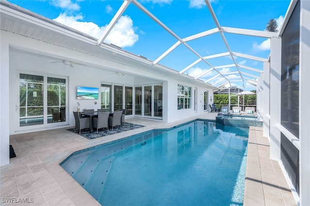 view of pool with ceiling fan, a patio, glass enclosure, and a pool with connected hot tub