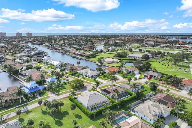 aerial view of property and surrounding area with a large body of water and nearby suburban area